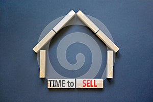 Time to sell house symbol. Concept words `Time to sell` on wooden blocks near miniature house. Beautiful grey background, copy