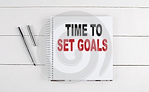 TIME TO SET GOALS text written on notebook on the wooden background