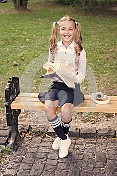 Time to study. Schoolgirl reading book. Little genius. Schoolgirl relaxing sit bench with book. Studying in school yard