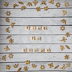 TIME TO STUDY words is written on a white wooden table with frame of scattered summer flowers and butterflies