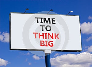 Time to think big symbol. Concept words Time to think big on beautiful big white billboard. Beautiful blue sky cloud background.