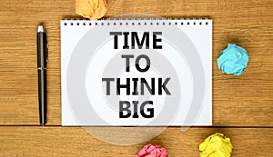 Time to think big symbol. Concept words Time to think big on beautiful white note. Beautiful wooden table background. Colored