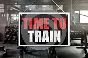 Time to Train Sign in front of a gym background. Motivation or encouragement concept. Hardcore fitness lifestyle