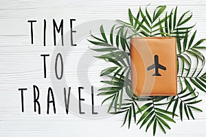 Time to travel text on passport with plane on green palm leaves