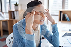 Time to wrangle these thoughts. a young businesswoman looking stressed while working at her desk in a modern office.