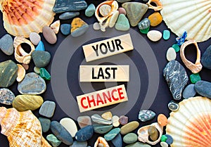 Time to your last chance symbol. Concept words Your last chance on wooden blocks on a beautiful black table black background. Sea