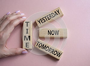Time - Yesterday Now Tomorrow. Wooden cubes with words Time . Businessman hand. Beautiful pink background. Business and Time
