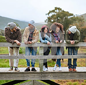 Time you enjoy wasting is never truly wasted. a group of friends hanging out on a wooden bridge together.