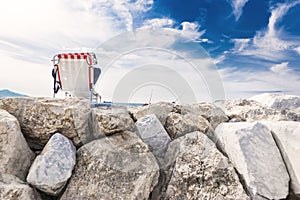 Time for yourself. A man in a deckchair, on a stone breakwater, against the blue sky. Vacation away from the city, fishing