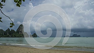 Timelaps of rain clouds moving towards the beach, limestone cliff rocks on background, Railay Beach Krabi Thailand