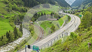 Timelapse, car traffic on the highway in the mountains next to the river. Cars drive from tunnels over bridges between mountains