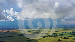 Timelapse of clouds movement against the background of green fields.