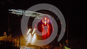 Timelapse: fast moving cars traffic, light trails along the dark road at night