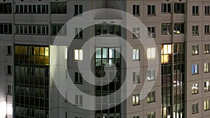 timelapse flashing lights in the windows of a large apartment building. Burning light inside windows at night