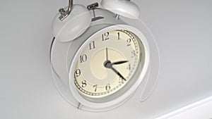 Timelapse. The hands on the dial of the white alarm clock is moving fast.