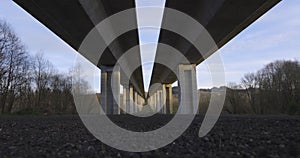 Timelapse of highway bridge underpass structure with concrete columns on a blue sky background