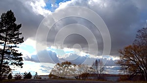 Timelapse - low cumulus and thunderclouds fly over the lake shore. Change of cyclone to anticyclone. Autumn landscape