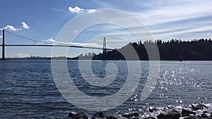 A timelapse movie of the Lion`s Gate Bridge and the ocean at day time.