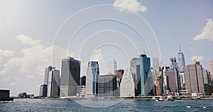 Timelapse of New York, Manhattan from East River. 4K. Scenic panorama of sunny skyscrapers, financial downtown district.