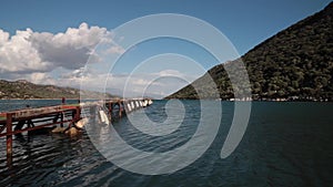 Timelapse of old wooden pier in the sea with mountains on backgorund