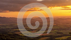 Timelapse of an orange-golden sunset over the Beskydy Mountains and the surrounding landscape with villages lying in a valley Gold