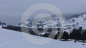 Timelapse of people sledging in the Swiss Alps. Mountains covered with snow. Ski resort AtzmÃ¤nnig, Canton of St. Gallen,