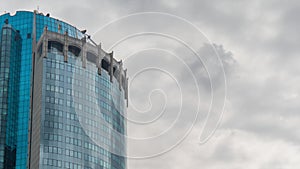 Timelapse - reflection of moving white clouds in glass wall of skyscraper