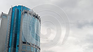 Timelapse - reflection of moving white clouds in glass wall of skyscraper