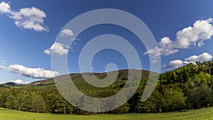 Timelapse of shadows and clouds moving on slopes of Radhost Hill overlooking a broadcast tower in a dense forest with moving shado