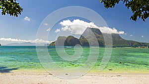 Timelapse from sunny exotic beach with clouds hovering over neighbouring island