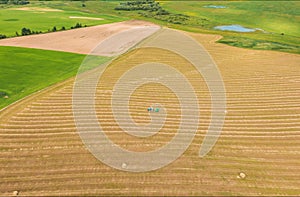 Timelapse Time lapse Dronelapse Hyperlapse. Aerial View Tractor Collects Dry Grass In Straw Bales In Wheat Field