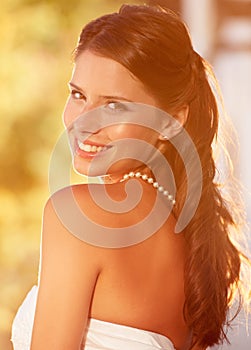 Timeless beauty. Portrait of a beautiful young bride looking over her shoulder and smiling at the camera.