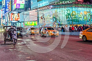 Times Square in New York City Manhattan at Night. Traffic on the Road and Toys R Us Store in Background