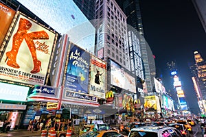 Times Square at night featuring lighted billboards of the broadway best show