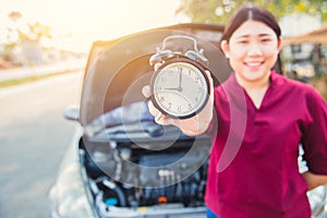 Times to car check concept: Asian women holding clock