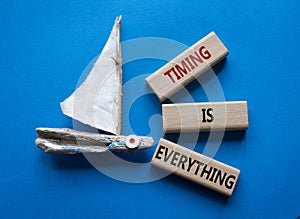 Timing is Everything symbol. Wooden blocks with words Timing is Everything. Beautiful blue background with boat. Business and