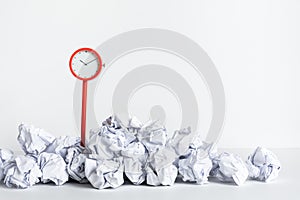 Timing and thinking idea with paper crumpled ball and red clock