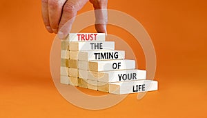Timing of your life symbol. Concept words Trust the timing of your life on wooden blocks on a beautiful orange table orange