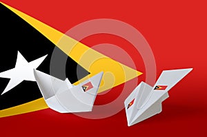 Timor Leste flag depicted on paper origami airplane and boat. Handmade arts concept photo