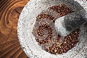 Timut sihuan pepper seeds in granite pestle or mortar