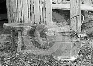 Tin bucket and an aluminum pot over the stool of the old stable