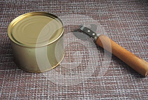 A tin can and a can opener. The opening of the cans