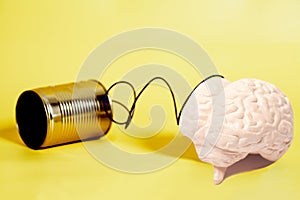 tin can phone with human brain anatomical model. communication concept