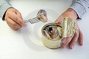 Tin can with ring in male hand. Close up. an empty label for design and text. an employee eats canned fish at work