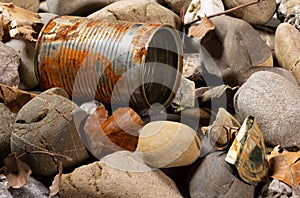 Tin can waste on pebble beach floor closeup