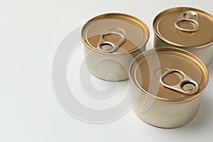 Tin cans with wet cat food on white background. Space for text