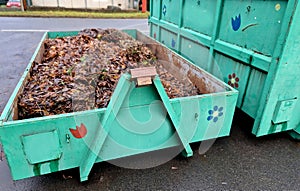 tin container for storing biowaste from a gardening company branches of leaves and cut grass open iron painted