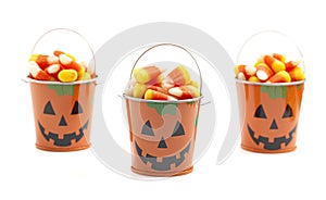 A Tin Pumpkin Jack O Lantern Bucket FIlled with Candy Corn on a White Background