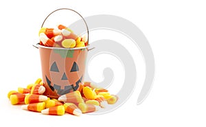 A Tin Pumpkin Jack O Lantern Bucket FIlled with Candy Corn on a White Background