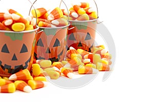 A Tin Pumpkin Jack O Lantern Bucket FIlled with Candy Corn on a White Background